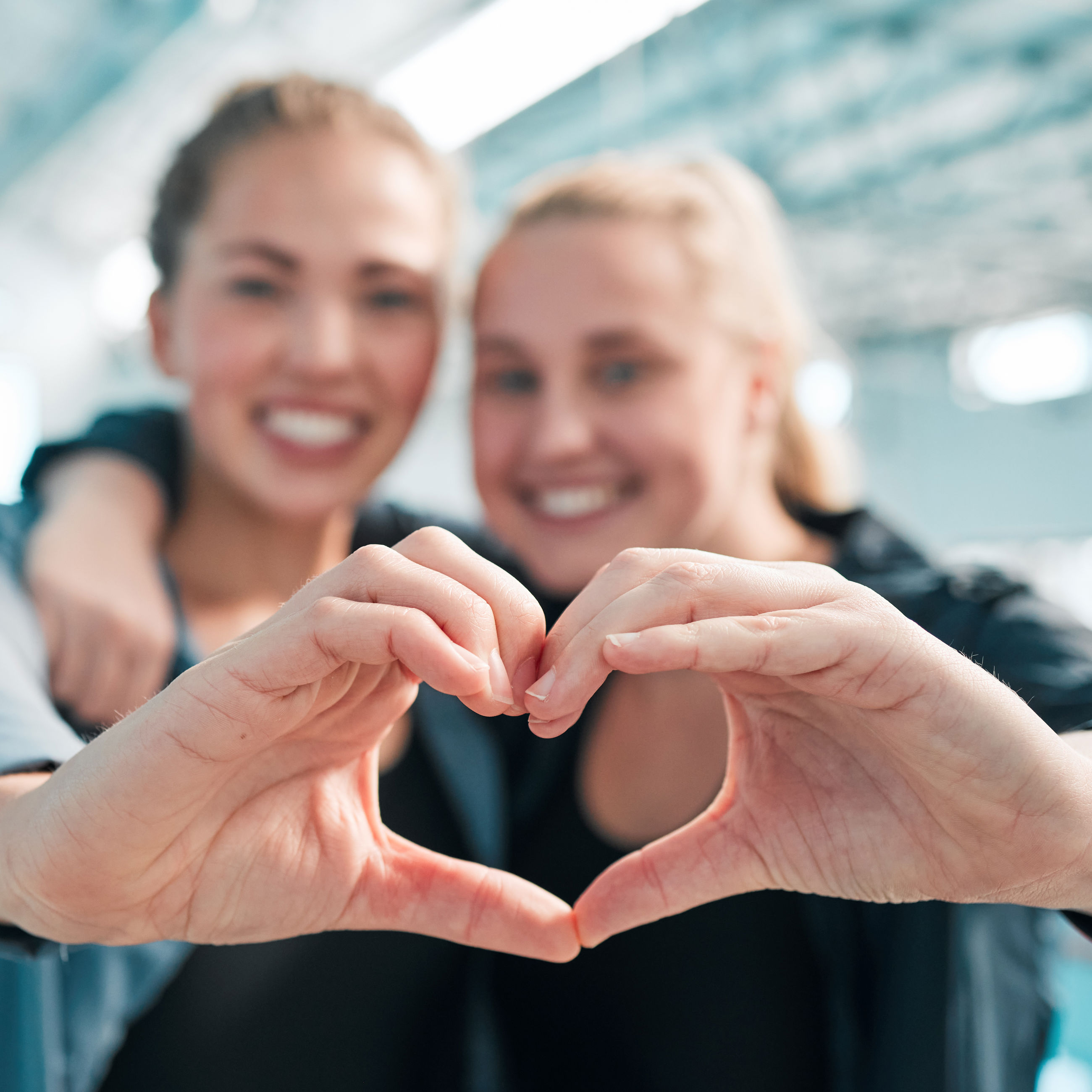 2 kvinder, der former et hjerte sammen med hænderne
