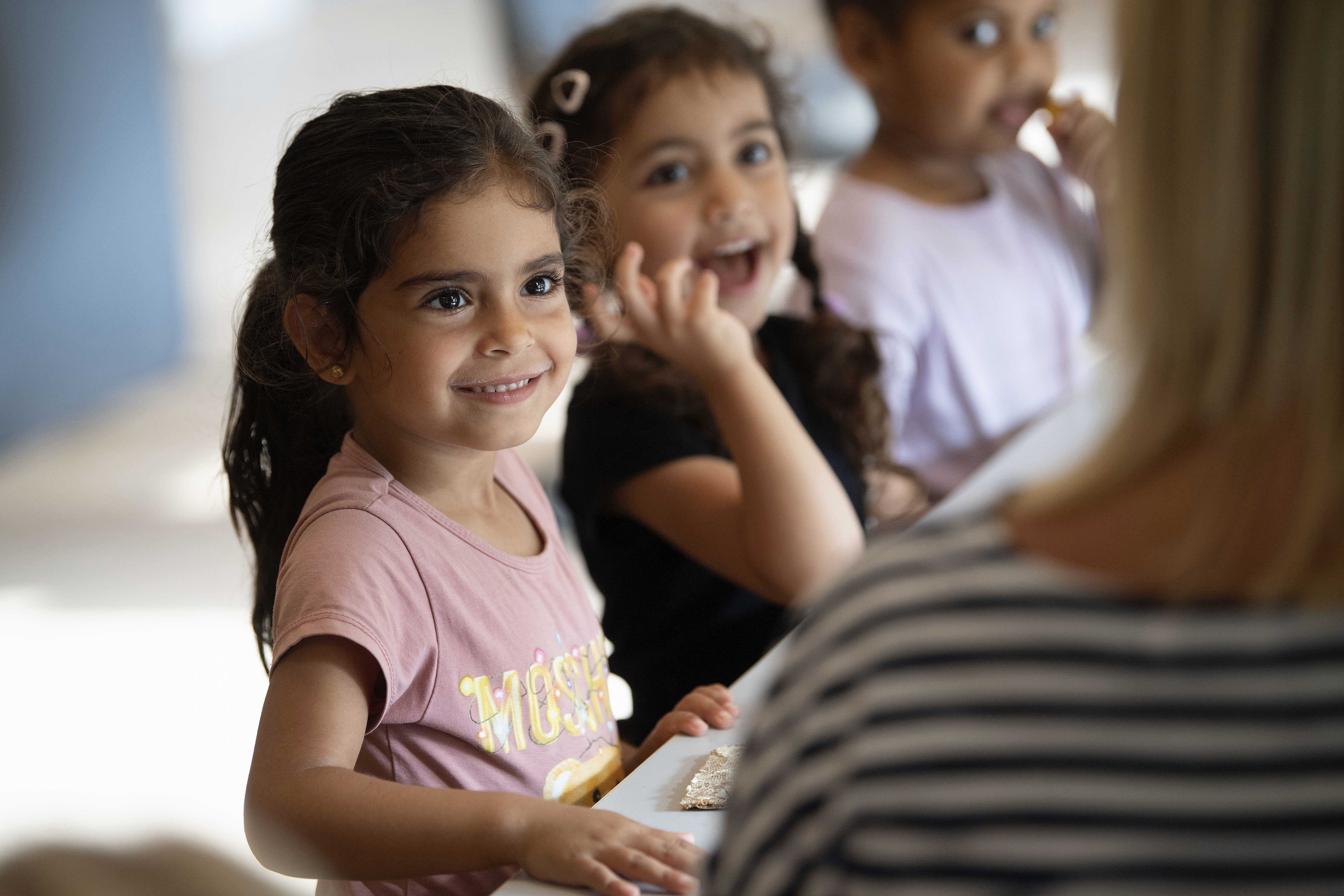Børn der smiler og sidder sammen