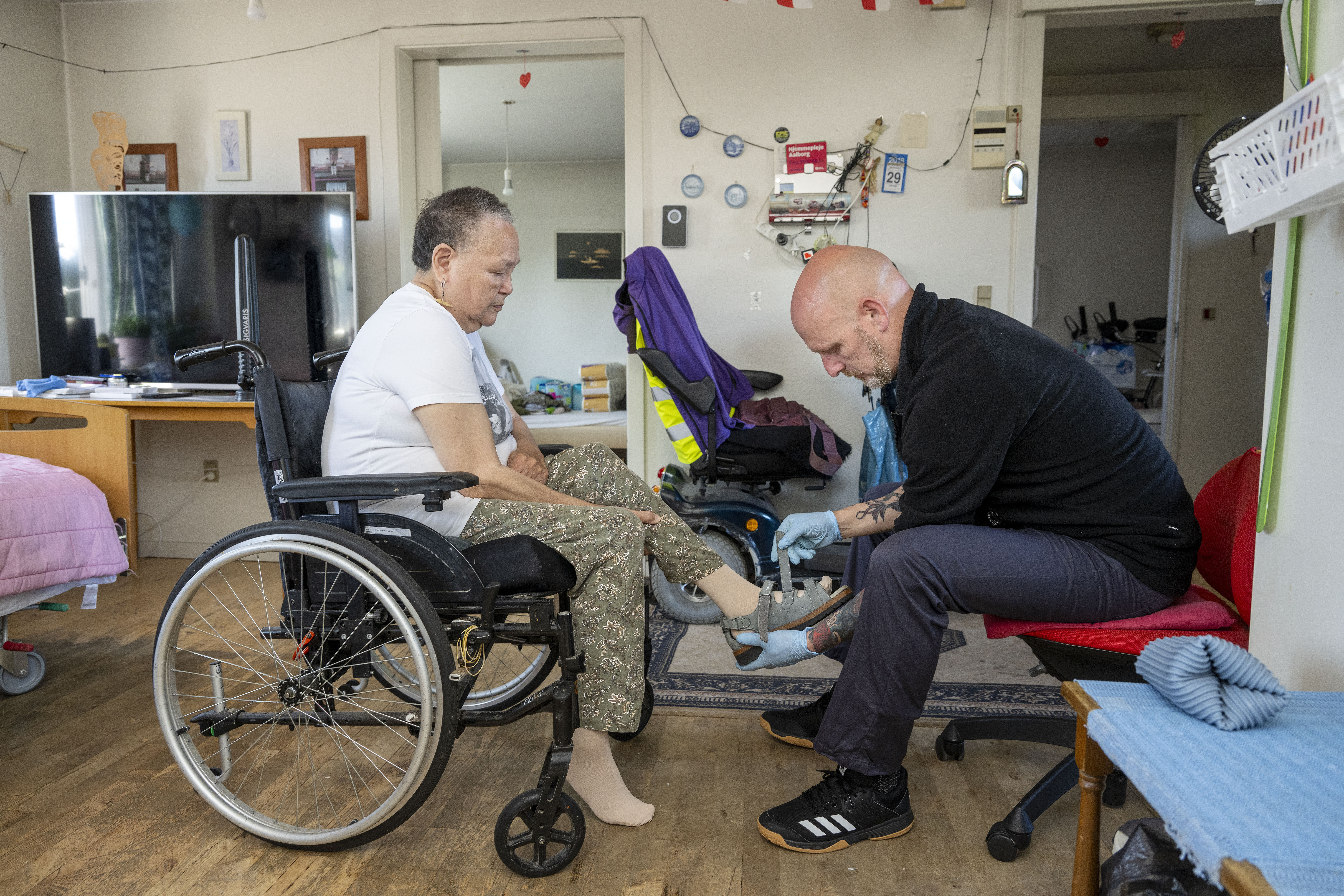 Medarbejder hjælper kvinde med sin sko