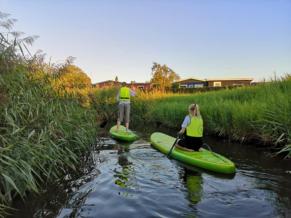 To børn, der står på SUP Board