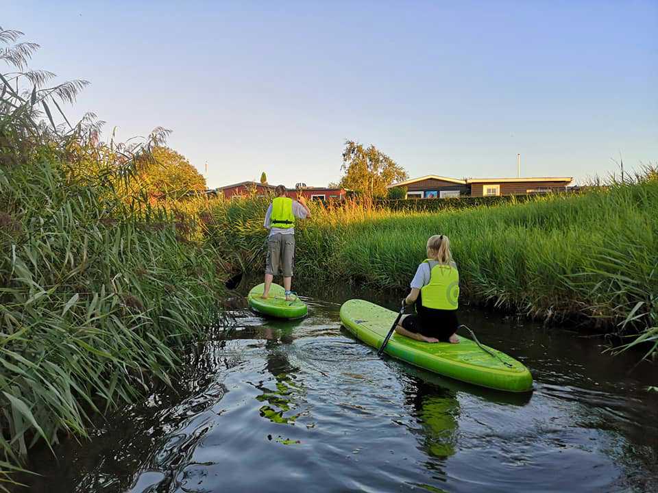 To børn, der står på SUP Board