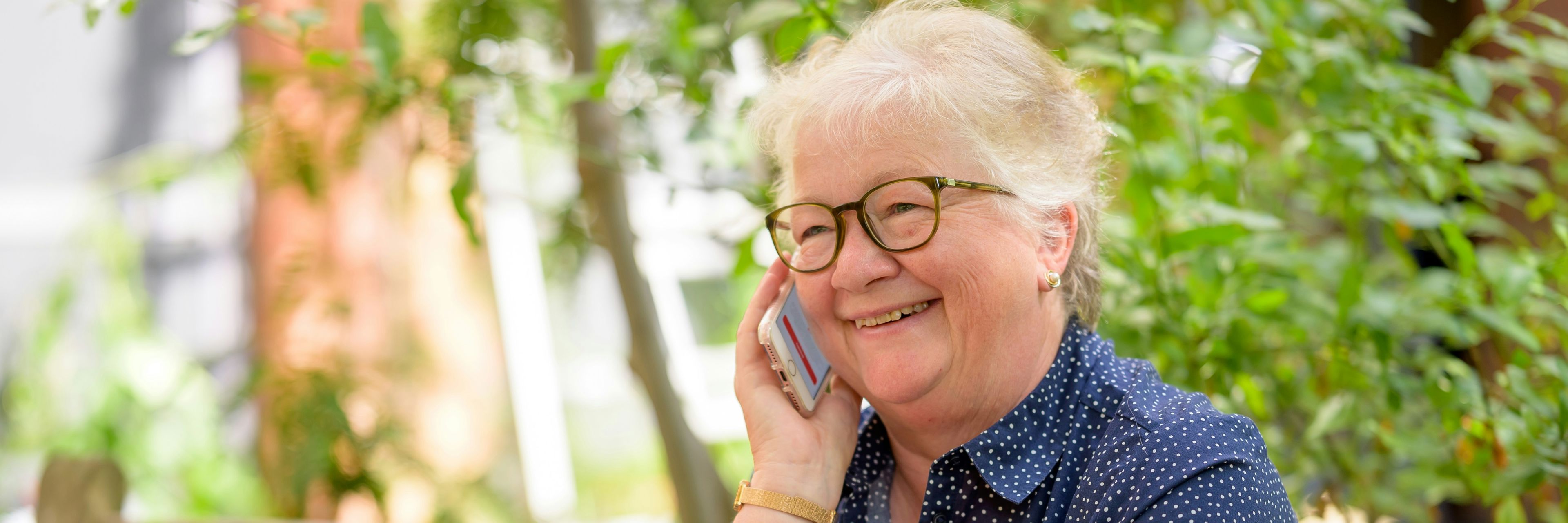 Dame taler telefon og arbejder ved pc