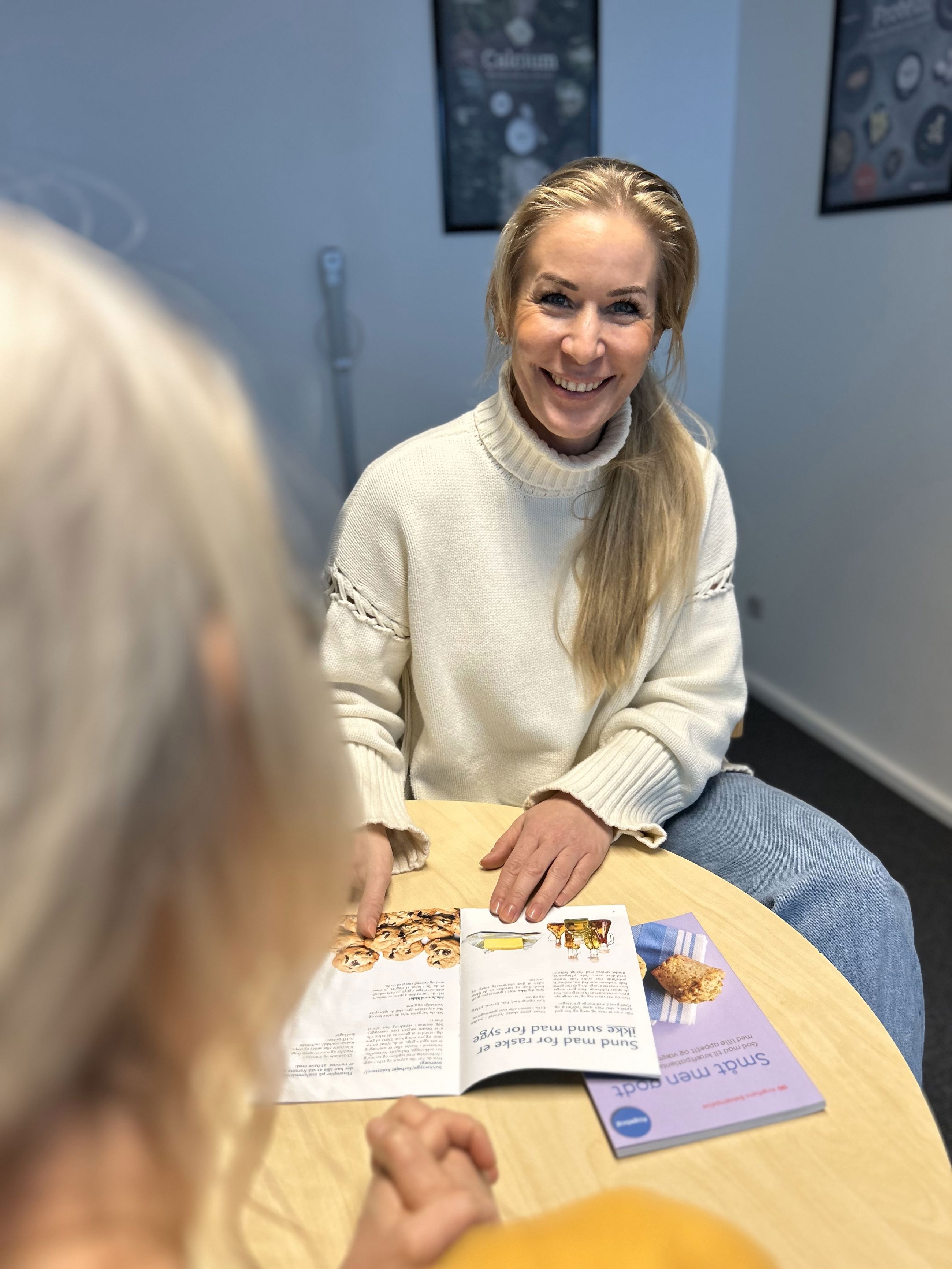 Siddende kvinder sidder med kostfolder