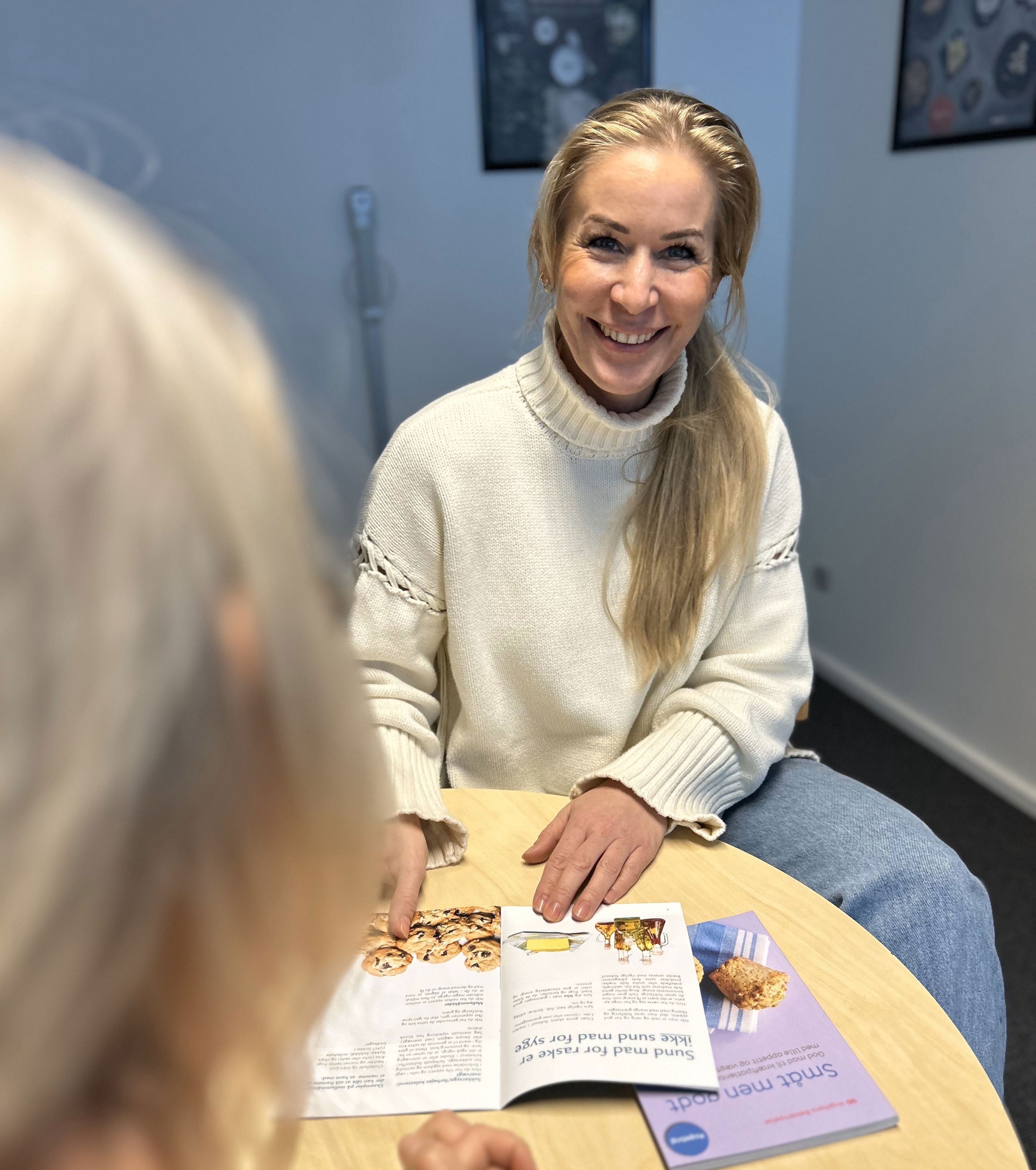 Siddende kvinder sidder med kostfolder