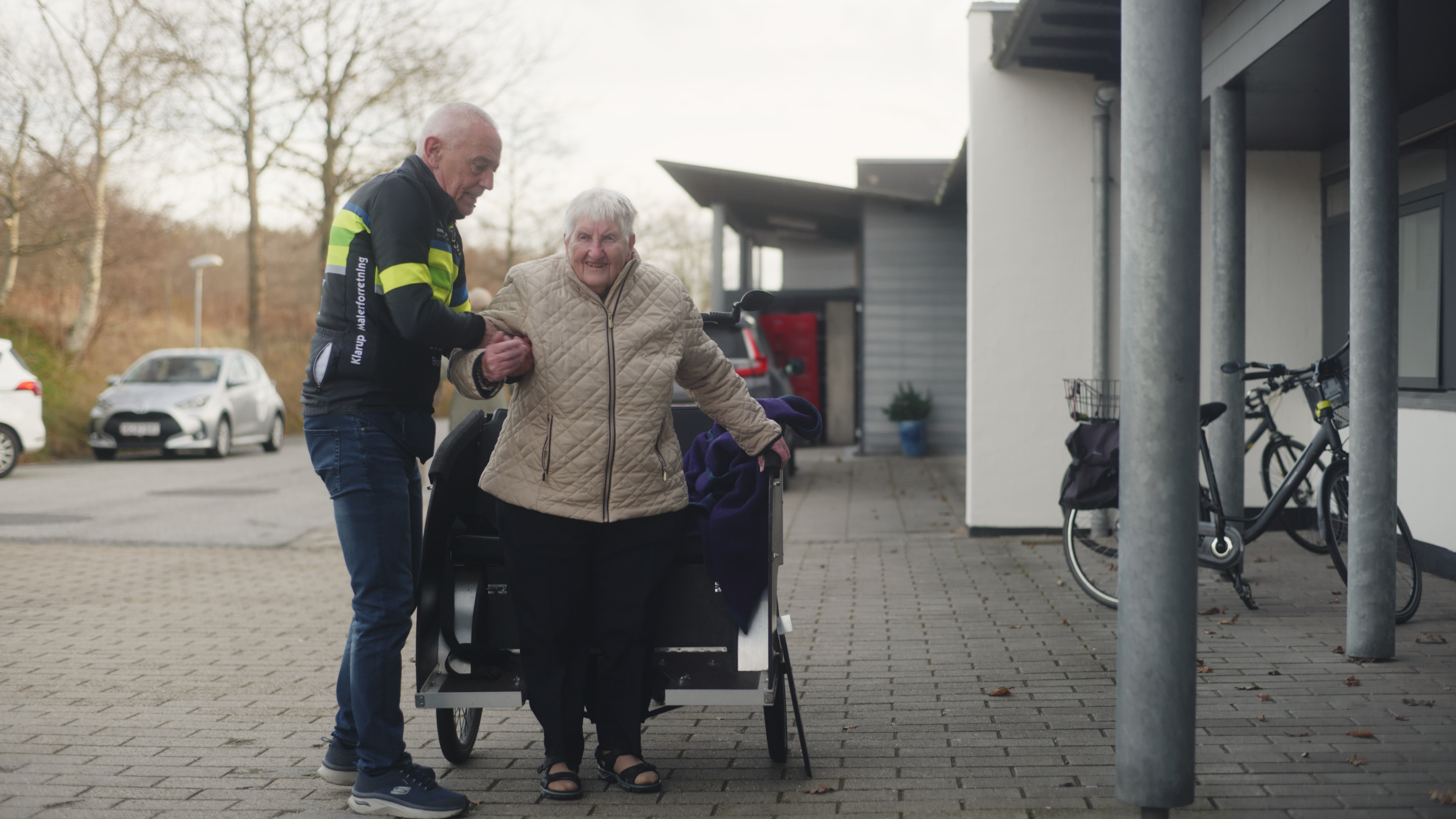 Bent hjælper ældre dame ud af cyklen