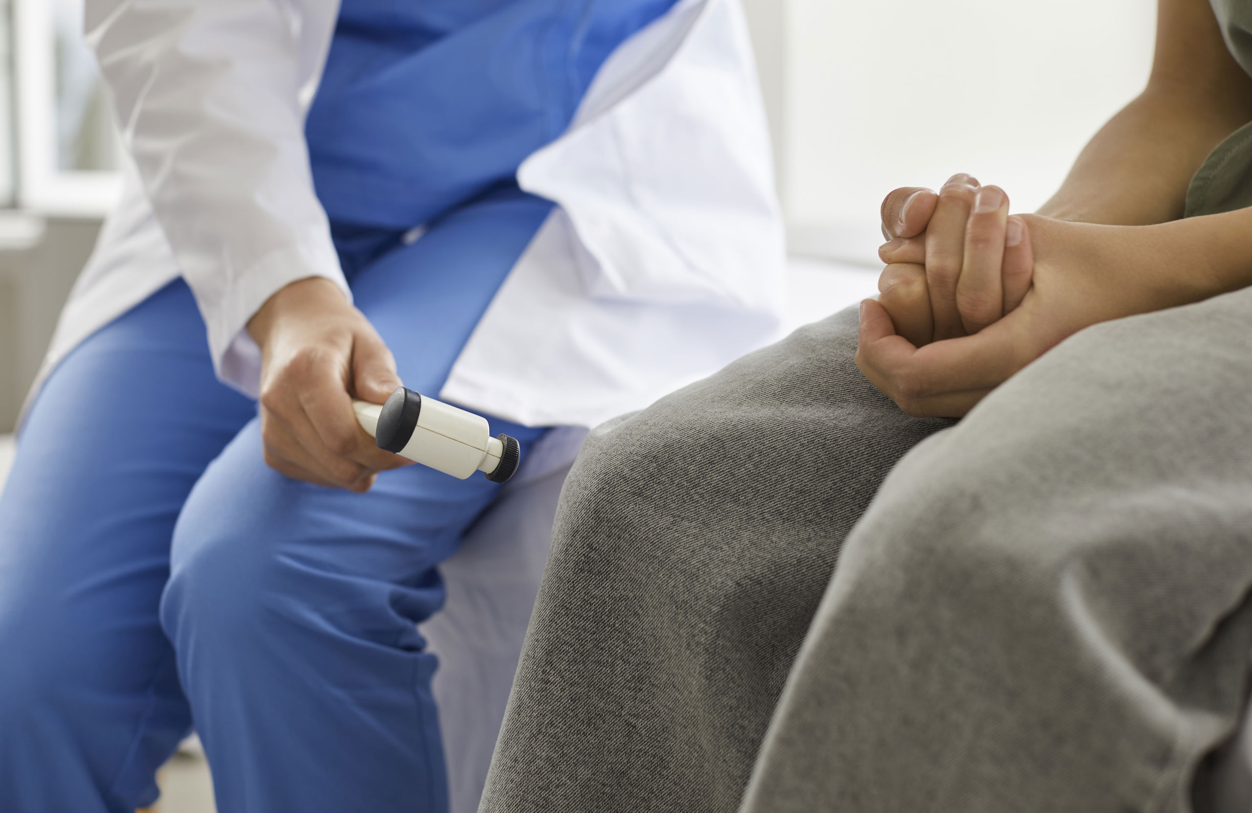 Læge tjekker reflekser hos patient