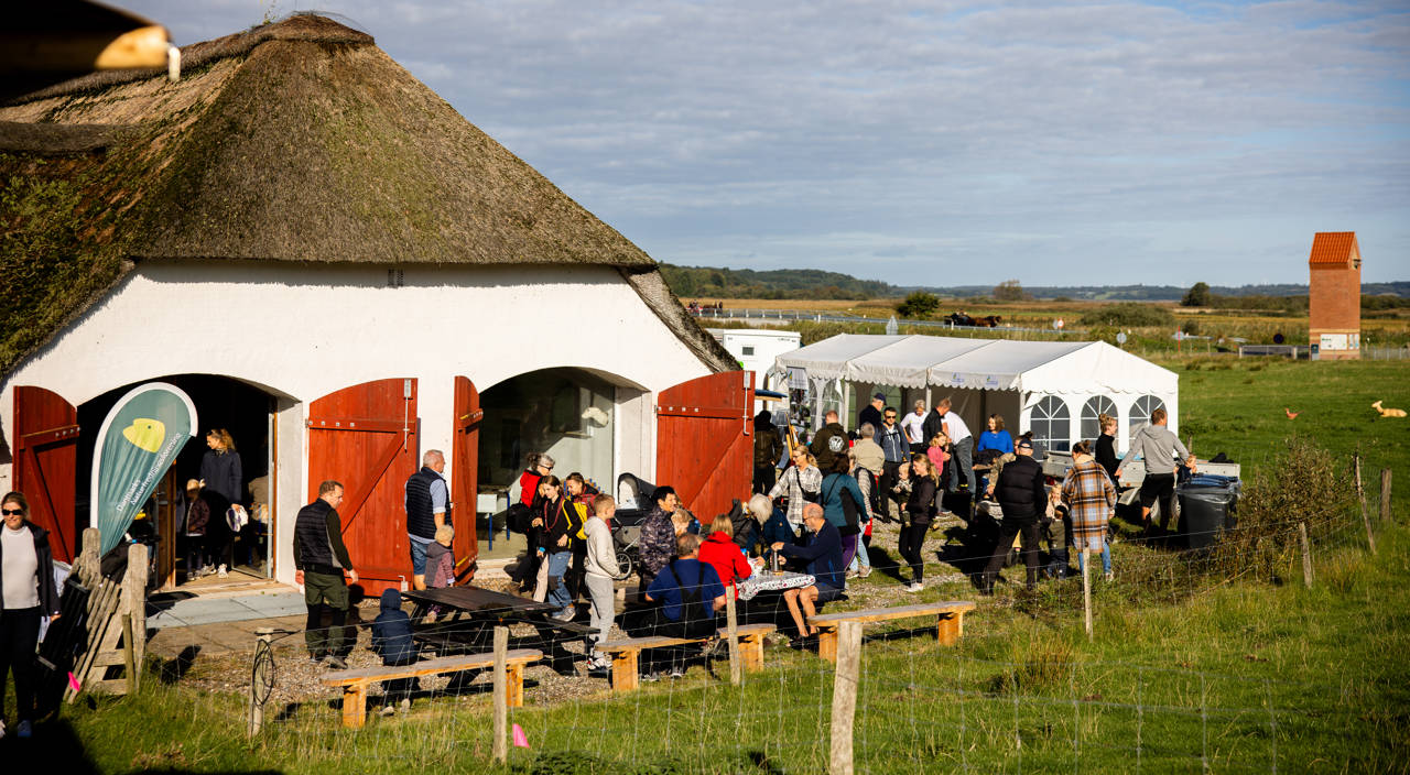 Børn og voksne sidder ved borde