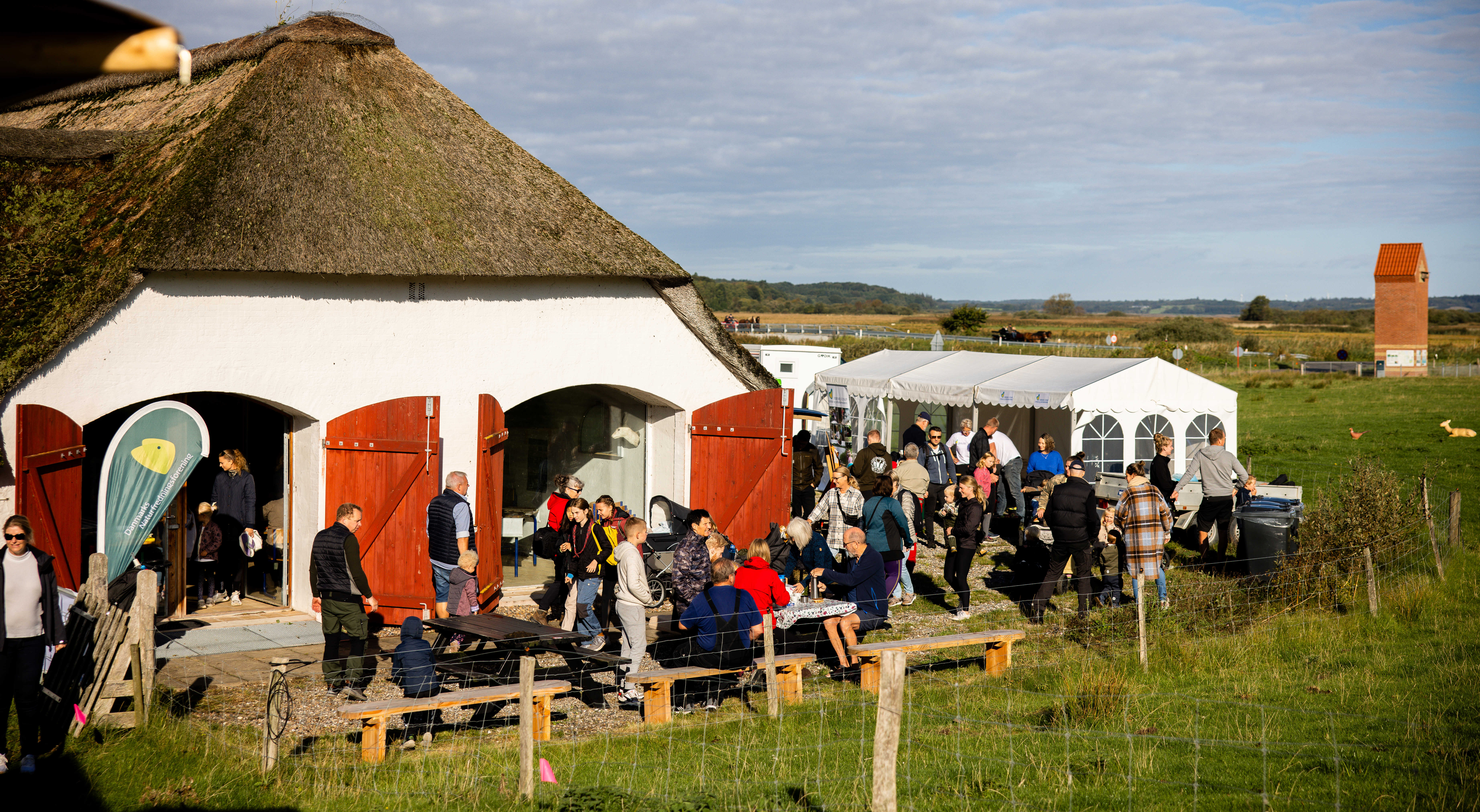 Børn og voksne sidder ved borde