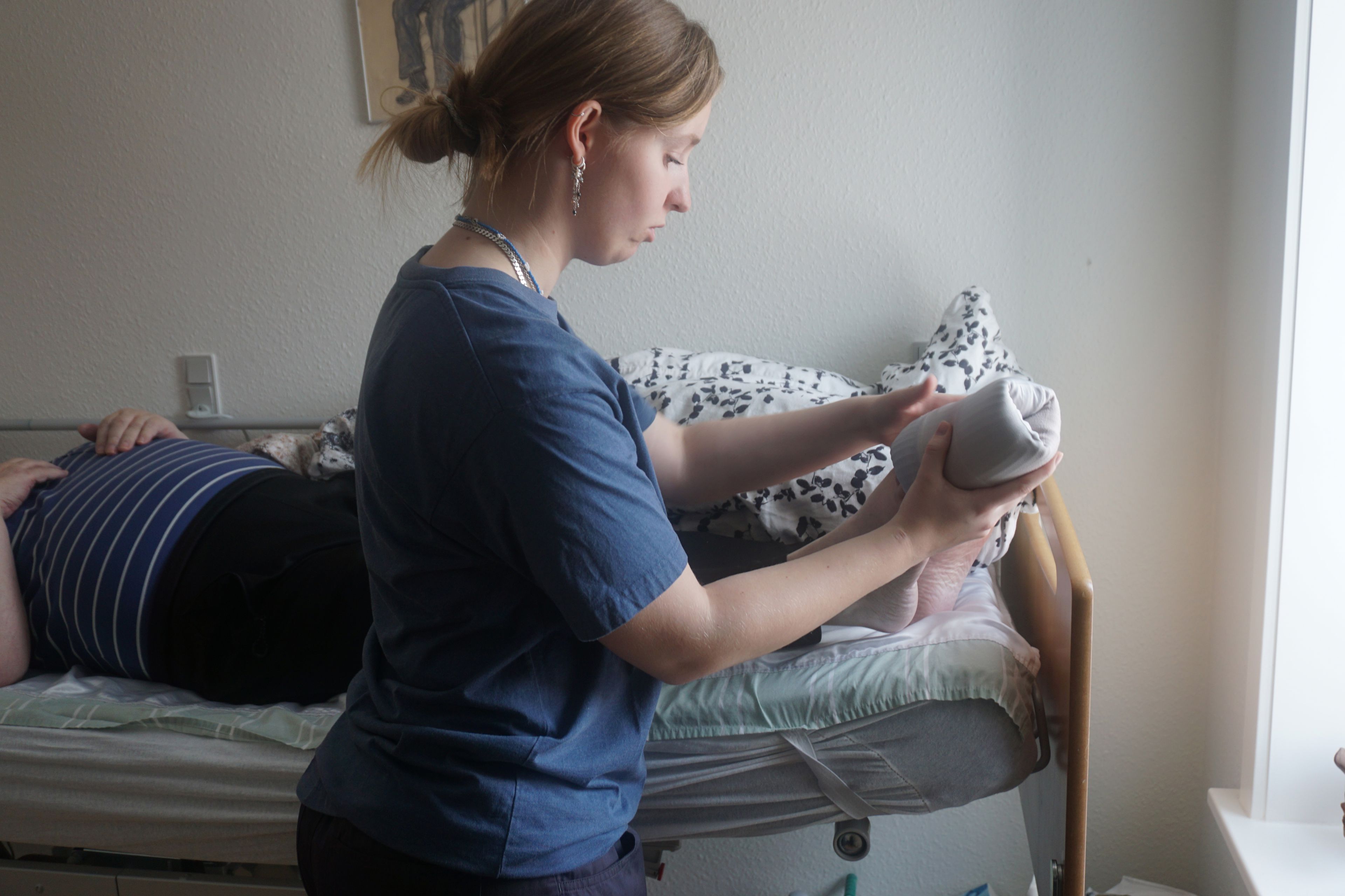 EUX-elev hjælper med at tage strømpe på