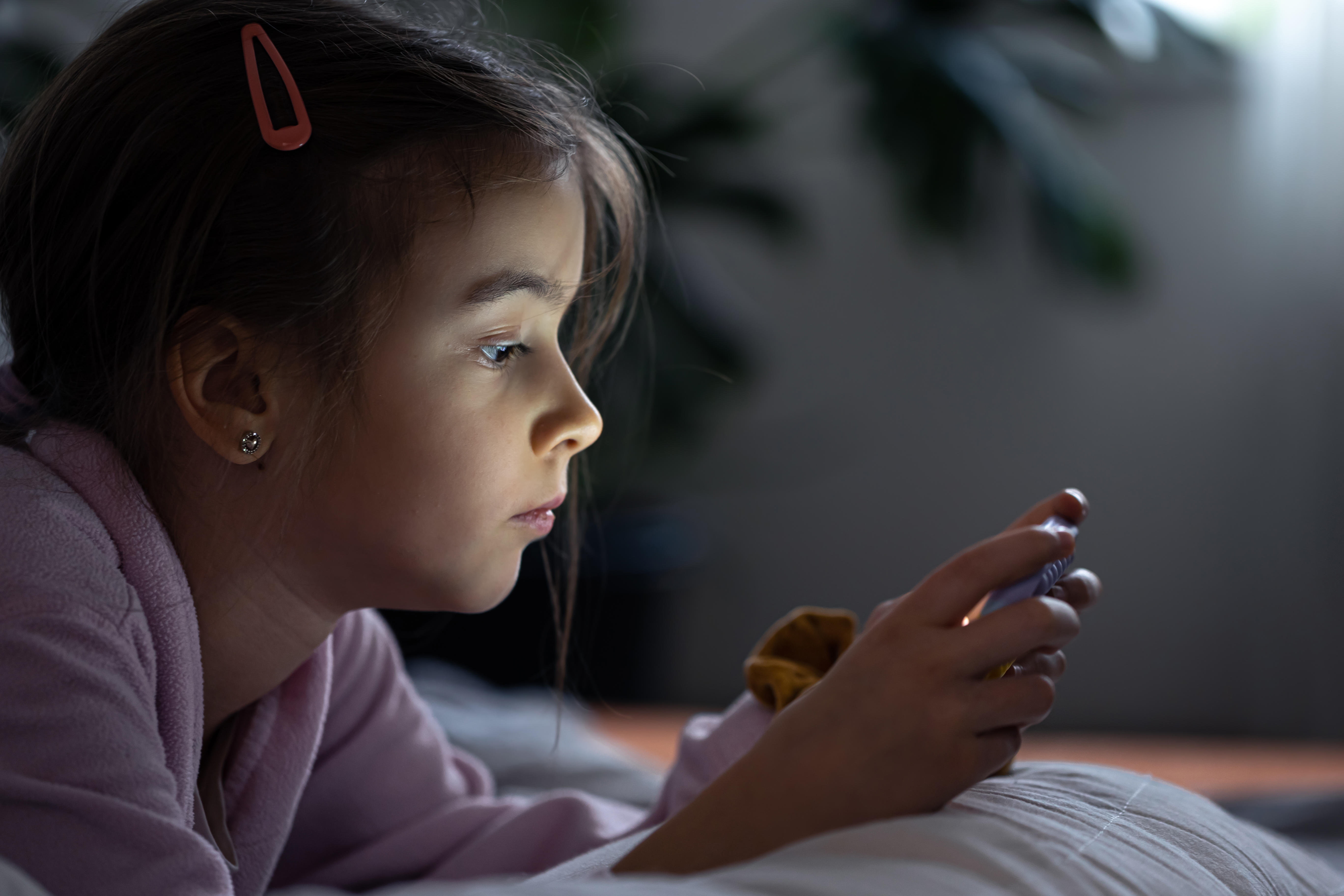 Pige i mørke og kigger på sin telefon