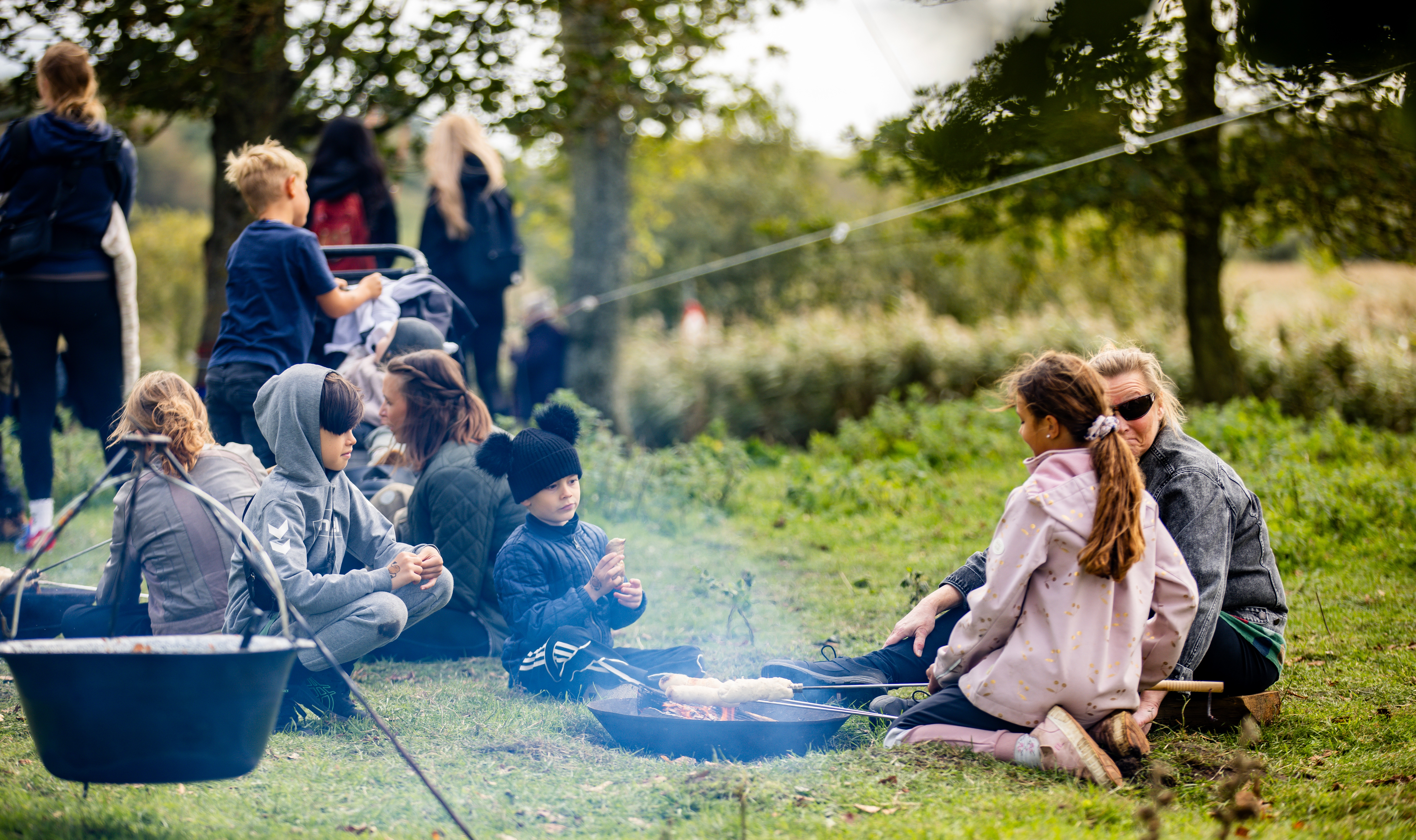 Børn og voksne der bager snobrød