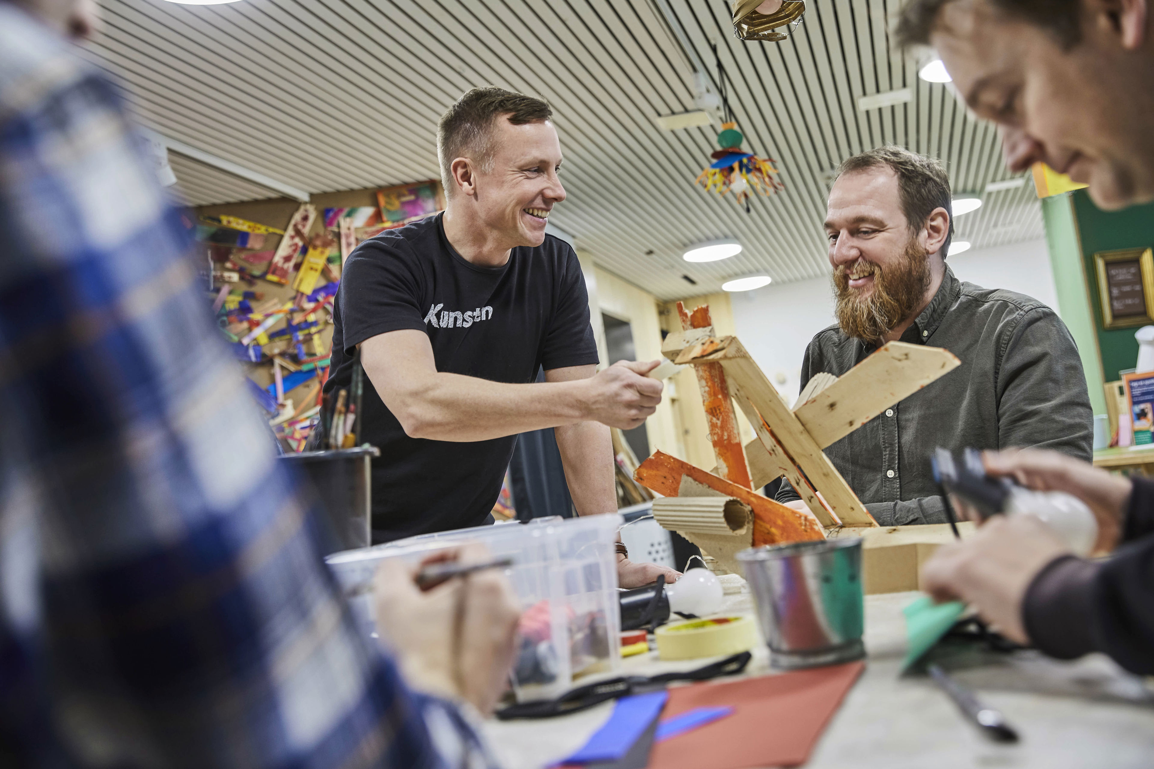 To mænd omkring bord med kreative rekvisitter